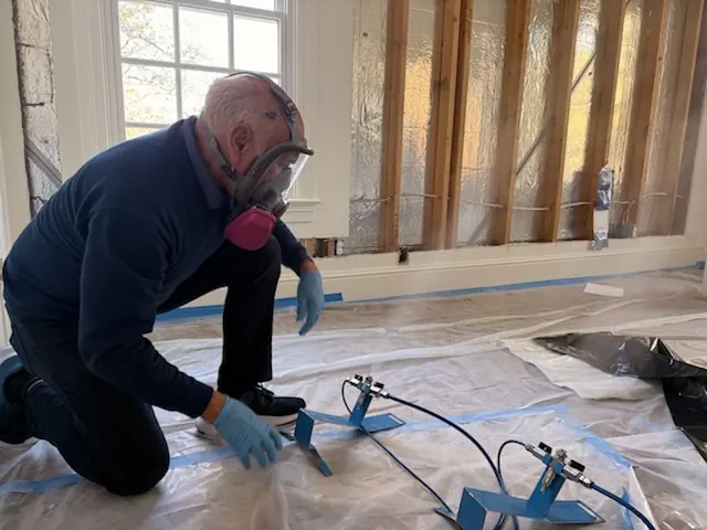 A restoration technician setting drying equipment in a Raleigh home stripped to the studs