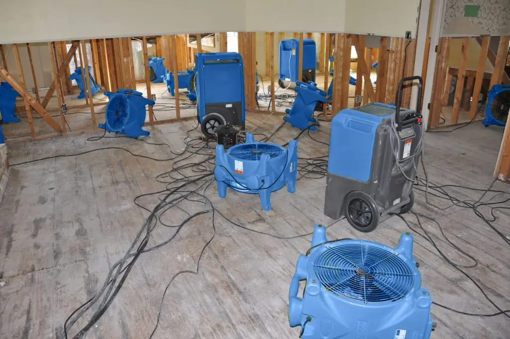 Air movers drying a gutted Raleigh room after major water damage